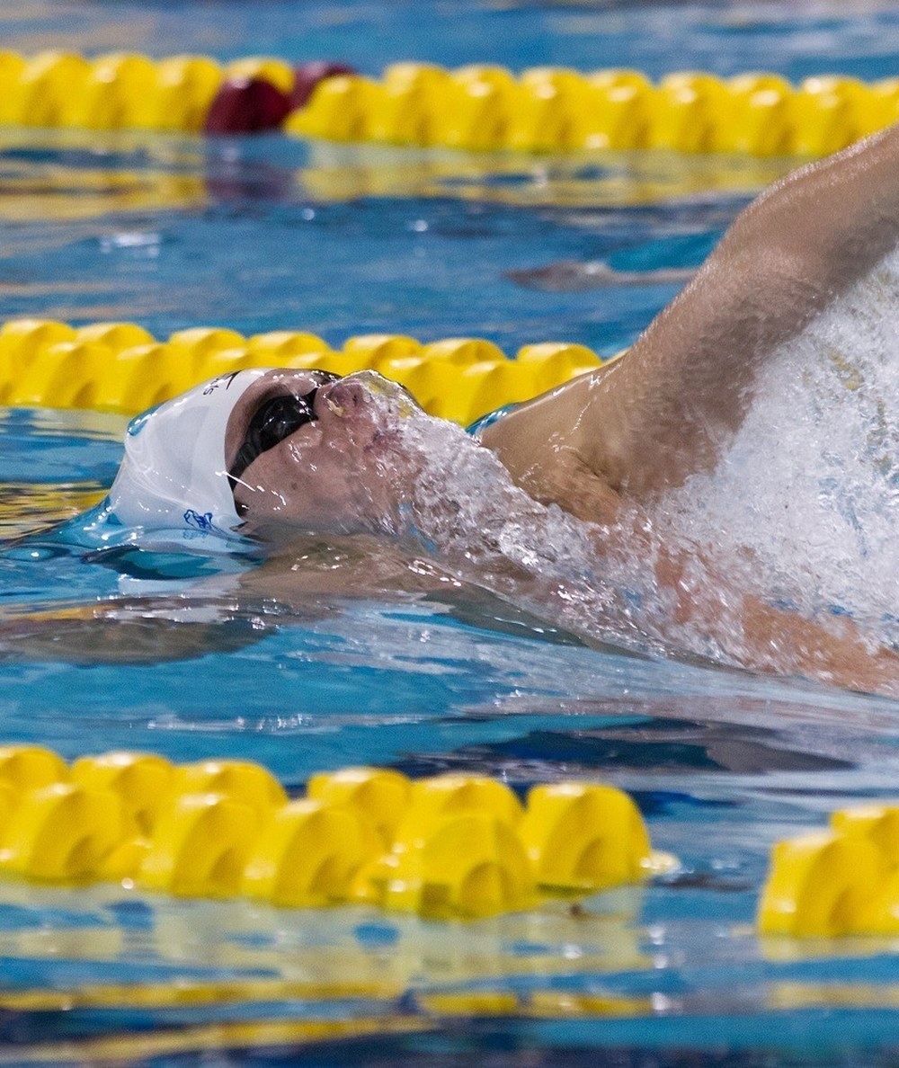 Close-up of Marco Loughran swimming backstroke in competition
